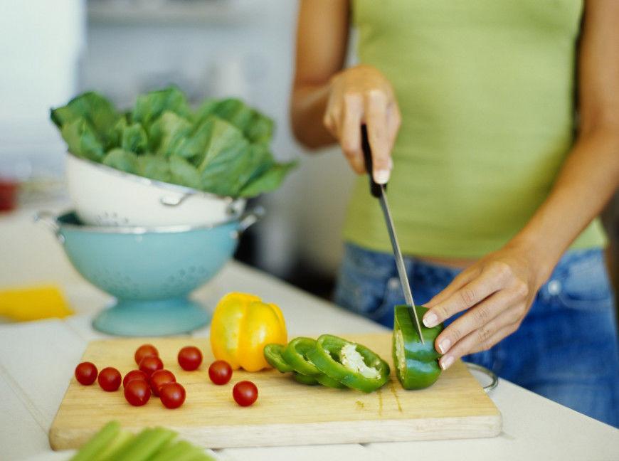 mid section view of a woman cutting vegetables --- Image by © Royalty-Free/Corbis